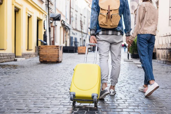 Cropped view of couple holding hands and traveling together — Stock Photo