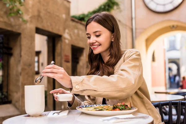 Selektiver Fokus einer Frau, die in einem Café in der Stadt Zuckerwürfel in eine Tasse Tee gibt — Stockfoto