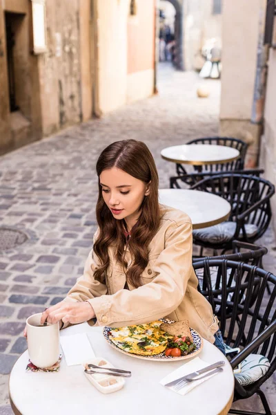 Selective focus of woman stirring Sugar in cup of tea in cafe in city — Stock Photo