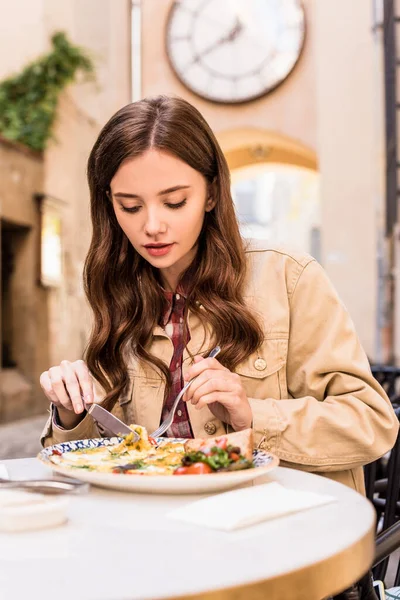 Selective focus of woman eating omelette in cafe in city — Stock Photo