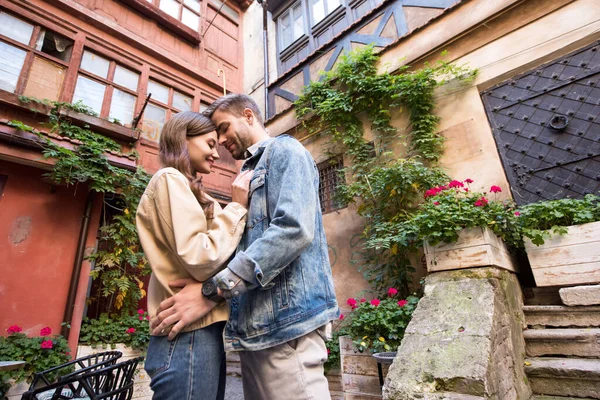 Low angle view of couple hugging near building in city — Stock Photo