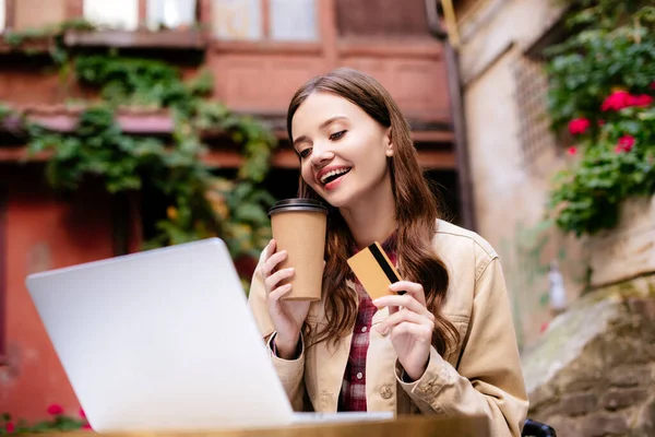 Concentration sélective de la femme avec carte de crédit en utilisant un ordinateur portable dans le café — Photo de stock