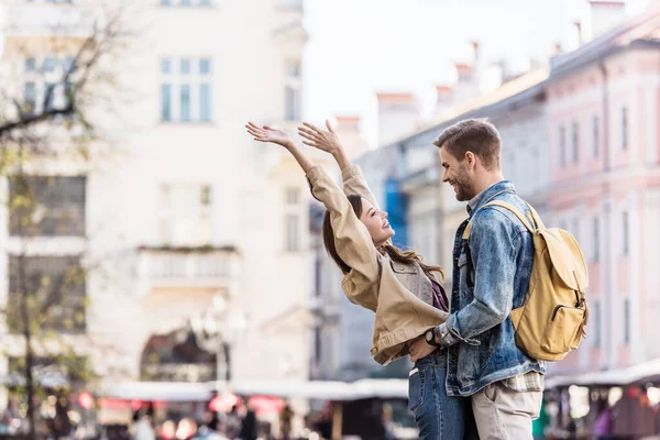 Boyfriend and girlfriend looking at each other and smiling in city — Stock Photo