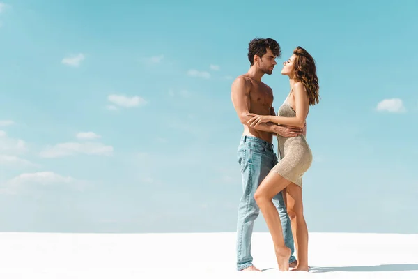 Vista lateral de apasionada sexy joven pareja abrazando en la playa — Stock Photo