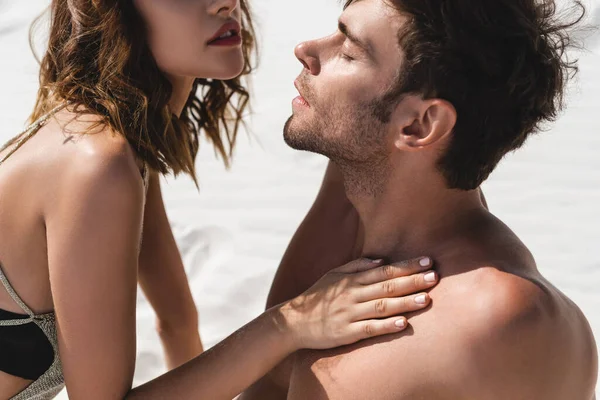 Apasionada sexy joven pareja en la playa bajo la luz del sol - foto de stock