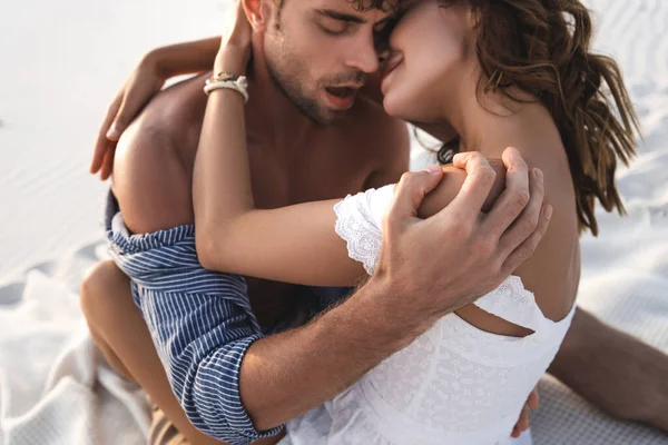 Apasionada joven pareja besándose en arenosa playa - foto de stock