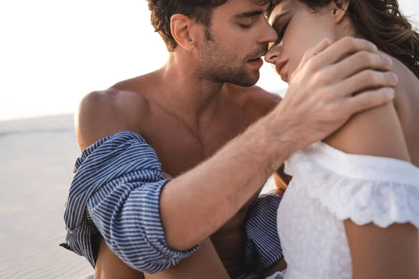 Apasionada joven pareja besos en playa - foto de stock