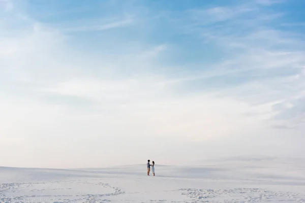 Casal em pé na praia de areia com céu azul — Fotografia de Stock