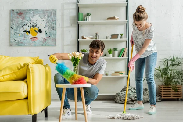 Homme et femme heureux faisant le nettoyage de printemps dans l'appartement — Photo de stock