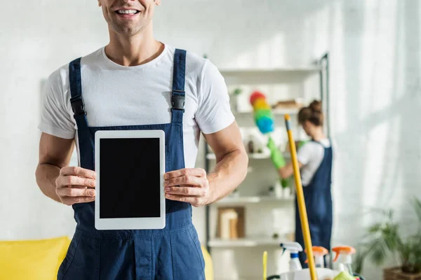 Vue recadrée du nettoyeur heureux tenant tablette numérique avec écran blanc — Photo de stock