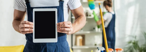 Plano panorámico del limpiador que sostiene la tableta digital con la pantalla en blanco - foto de stock