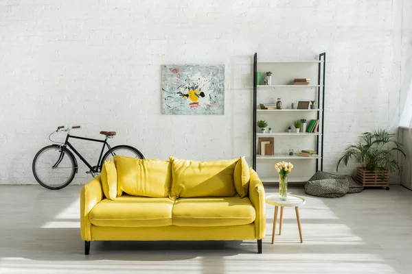 Canapé, vélo et étagère dans le salon moderne — Photo de stock