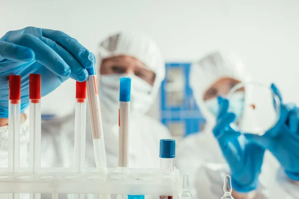 Foco seletivo do bioquímico tomando tubo de ensaio perto colega segurando placa de Petri — Fotografia de Stock