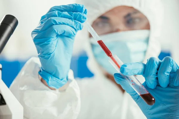 Selective focus of biochemist taking blood sample from test tube with pipette — Stock Photo