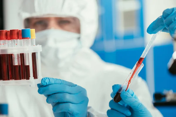 Selective focus of biochemists holding test tubes with blood samples — Stock Photo