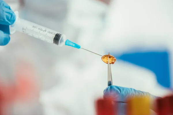 Cropped view of biochemist making injection to capsule — Stock Photo