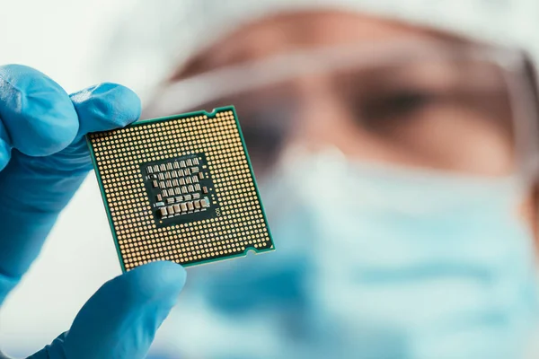 Enfoque selectivo del ingeniero que sostiene el microchip de la computadora - foto de stock