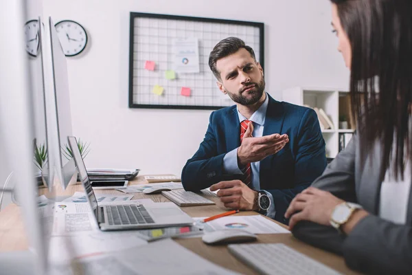 Selektiver Fokus des Datenanalysten bei der Arbeit mit Kollegen in der Nähe von Computern auf dem Tisch — Stockfoto