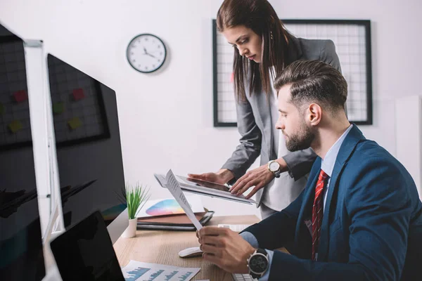 Enfoque selectivo de los analistas que trabajan en seguridad de la información con dispositivos digitales y papeles en la oficina — Stock Photo