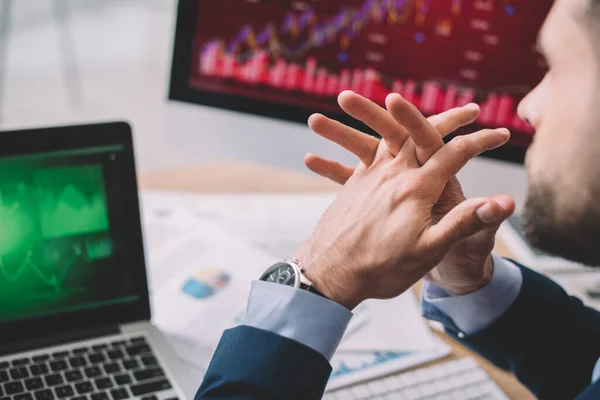 Selective focus of data analyst sitting at table with charts on computer monitors — Stock Photo