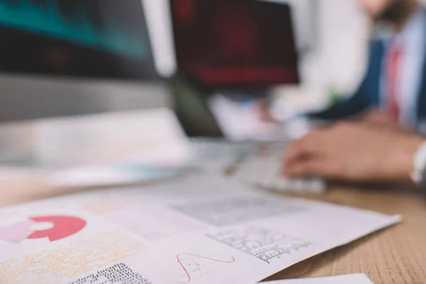 Selective focus of paper with graphs and data analysts working at table — Stock Photo