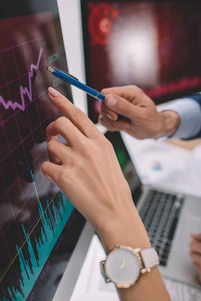 Cropped view of data analysts pointing on charts on computer monitors — Stock Photo