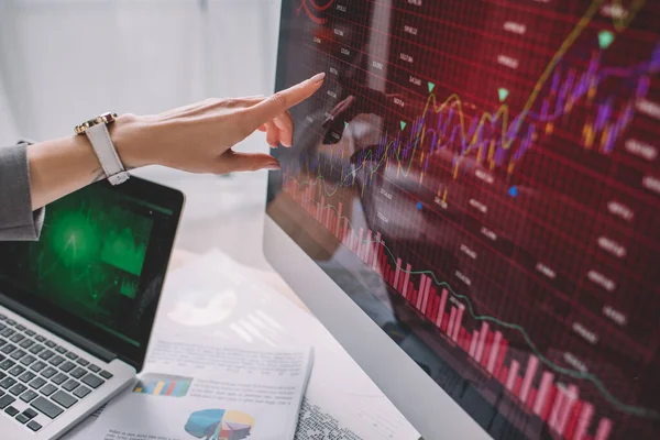 Vista recortada del analista de seguridad de la información apuntando con el dedo en los gráficos en el monitor de la computadora — Stock Photo