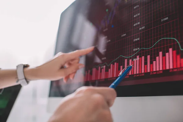 Selective focus of data analysts pointing on graphs on computer monitor while testing security of computer systems — Stock Photo