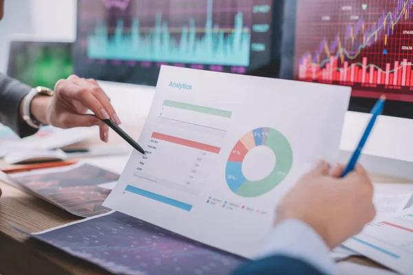 Cropped view of computer systems analysts working with charts at table — Stock Photo