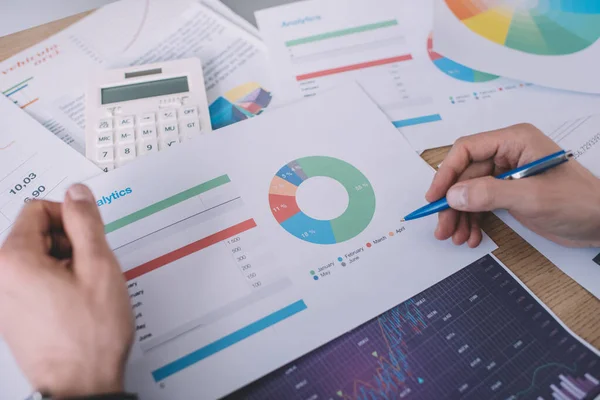 Cropped view of information security analyst planning strategy with charts at table — Stock Photo