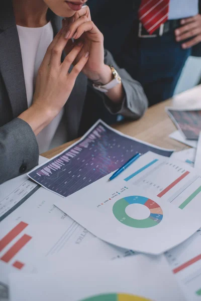 Cropped view of data analysts working with charts on table — Stock Photo