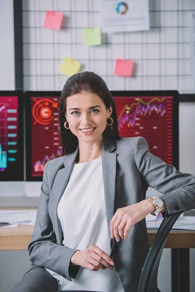 Bela analista de dados sorrindo para a câmera com o trabalho no escritório — Fotografia de Stock