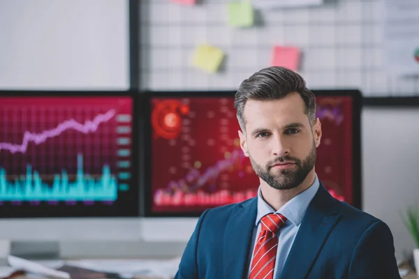 Ansehnlicher Datenanalytiker blickt im Büro in die Kamera — Stockfoto