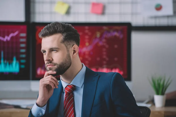 Analista de sistemas informáticos pensativo mirando hacia otro lado en la oficina - foto de stock