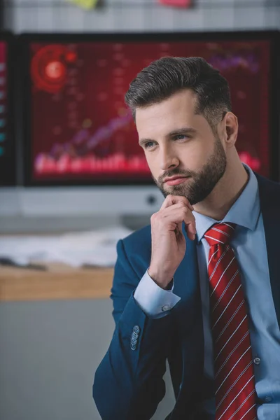 Analyste de données confiant avec la main près du menton regardant loin dans le bureau — Photo de stock