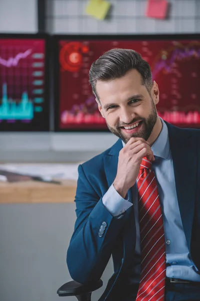 Handsome information security analyst smiling at camera while working in office — Stock Photo