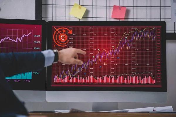Ausgeschnittene Ansicht eines Computersystemanalytikers, der mit dem Finger auf Graphen auf dem Computermonitor zeigt — Stockfoto