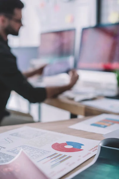 Focus selettivo di articoli con grafici su tabella e analista di dati che lavorano in ufficio — Foto stock