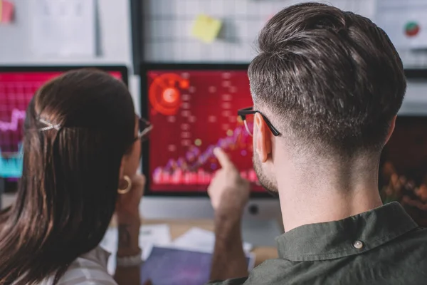 Vue arrière des analystes de données travaillant sur la protection des systèmes informatiques dans les bureaux — Photo de stock