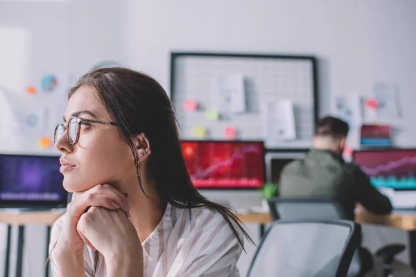 Focus selettivo dell'analista della sicurezza delle informazioni che distoglie lo sguardo mentre un collega lavora con i computer in ufficio — Foto stock