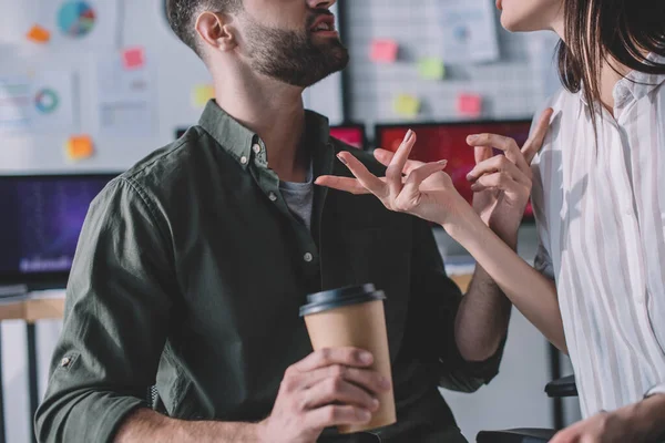 Cropped view of data analyst holding paper cup and talking to colleague — Stock Photo