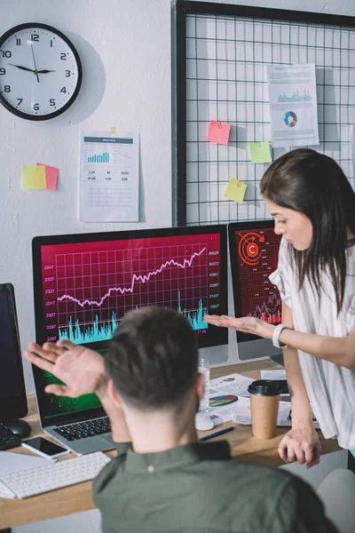 Selective focus of information security analysts pointing with hands on computer monitors with charts — Stock Photo