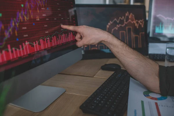 Cropped view of data analyst pointing on charts on computer monitor — Stock Photo