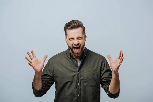 Angry man screaming at camera isolated on grey — Stock Photo