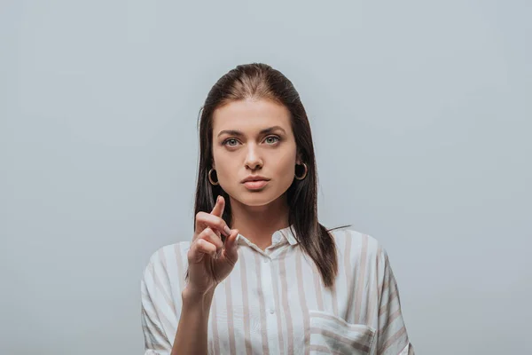 Attraktive Frau zeigt mit dem Finger auf Grau — Stockfoto