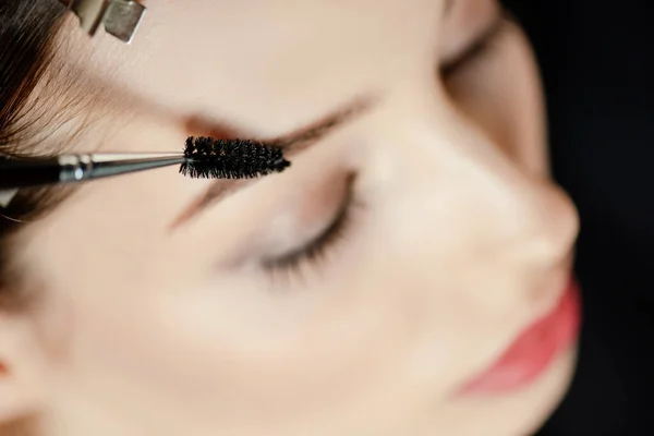 Selective focus of eyebrow brush near woman with closed eyes — Stock Photo