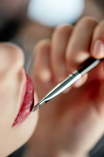 Cropped view of makeup artist applying lipstick on woman — Stock Photo