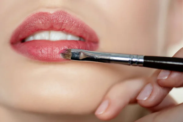 Recortado vista de maquillaje artista aplicación de lápiz labial en chica - foto de stock