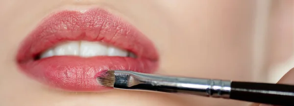 Tiro panorâmico de escova cosmética perto de lábios de menina — Fotografia de Stock