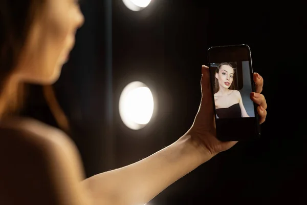 Foco seletivo da mulher tomando selfie no estúdio de fotografia — Fotografia de Stock